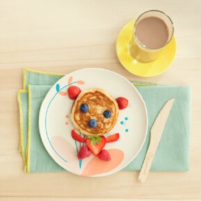 Pancakes decorated with berries and served with a glass of Nesquik Pancakes decorated with berries and served with a glass of Nesquik